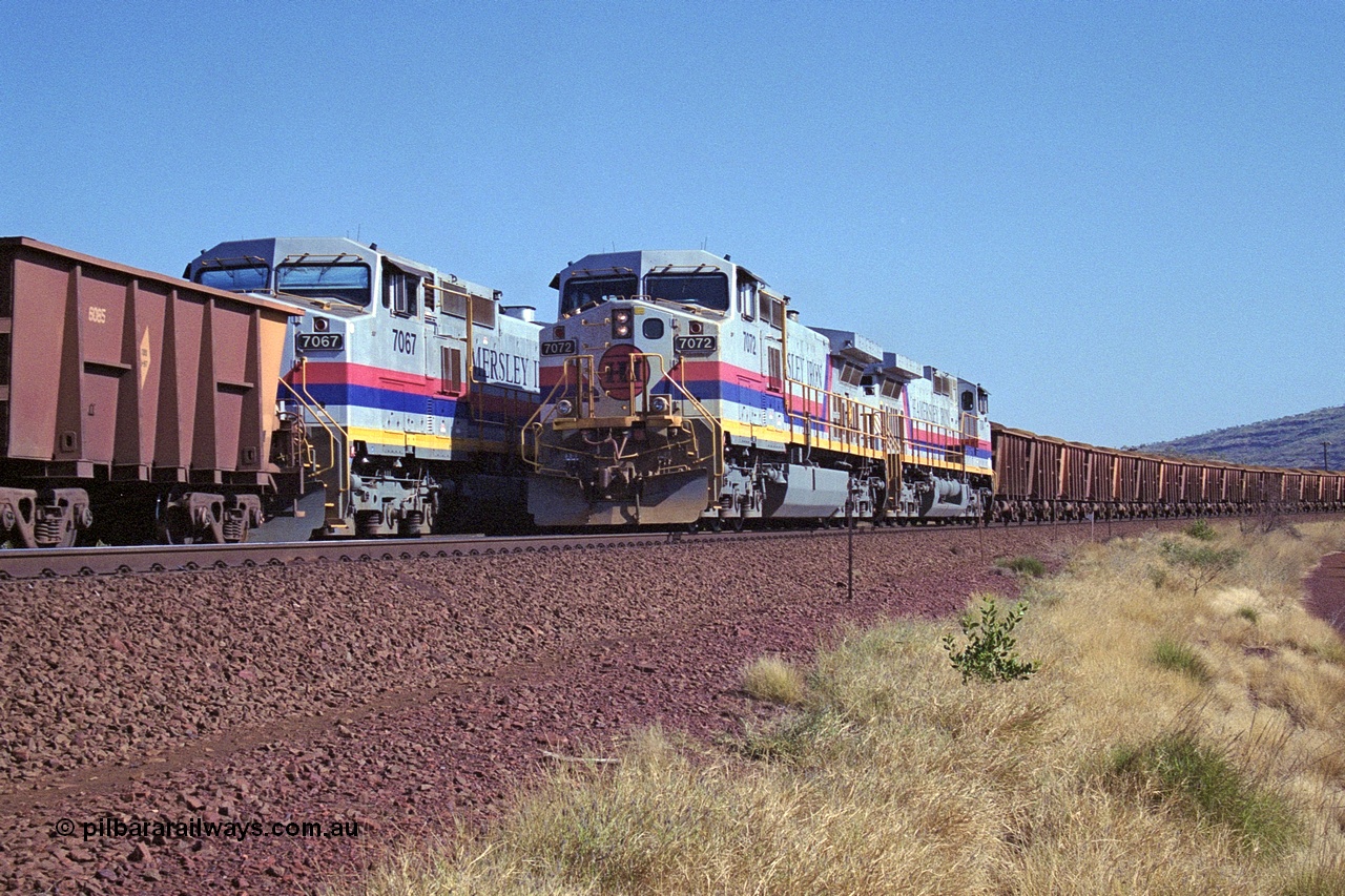 250-12
Pelican Siding on the Hamersley Iron Tom Price line about the 208 km with an empty train behind General Electric built 9-44CW units 7068 serial 47747 and 7067 serial 47746 on the loop as a loaded train with 210 waggons passes behind a sister pairing of 7072 serial 47751 and 7074 serial 47753. 1550 hrs 21st October 2000.
Keywords: 7072;GE;Dash-9-44CW;47751;
