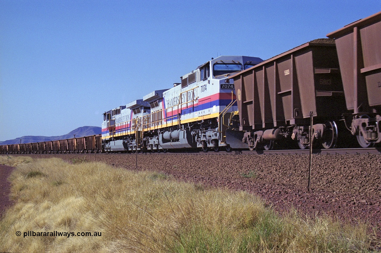250-13
Pelican Siding on the Hamersley Iron Tom Price line about the 208 km with an empty train behind General Electric built 9-44CW units 7068 serial 47747 and 7067 serial 47746 on the loop as a loaded train with 210 waggons passes behind a sister pairing of 7072 serial 47751 and 7074 serial 47753. 1550 hrs 21st October 2000.
Keywords: 7074;GE;Dash-9-44CW;47753;
