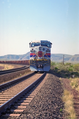 250-01
Pelican Siding on the Hamersley Iron Tom Price line about the 208 km with an empty train behind the standard pairing of two General Electric built 9-44CW units 7068 serial 47747 and 7067 serial 47746 stand on the loop or passing track for a meet with a loaded train. 21st October 2000.
Keywords: 7068;GE;Dash-9-44CW;47747;