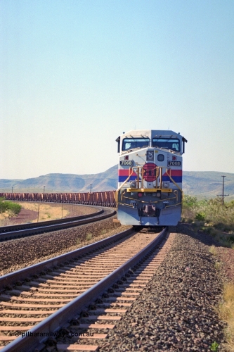 250-02
Pelican Siding on the Hamersley Iron Tom Price line about the 208 km with an empty train behind the standard pairing of two General Electric built 9-44CW units 7068 serial 47747 and 7067 serial 47746 stand on the loop or passing track for a meet with a loaded train. 21st October 2000.
Keywords: 7068;GE;Dash-9-44CW;47747;