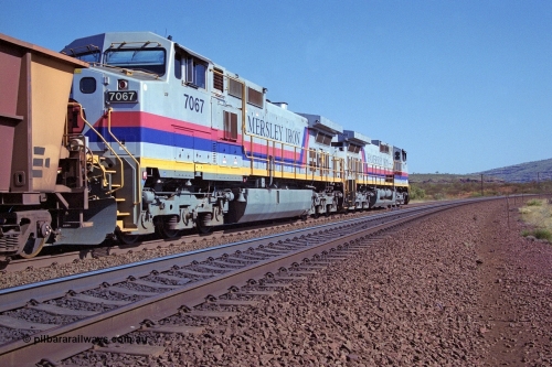 250-05
Pelican Siding on the Hamersley Iron Tom Price line about the 208 km with an empty train behind the standard pairing of two General Electric built 9-44CW units 7068 serial 47747 and 7067 serial 47746 stand on the loop or passing track for a meet with a loaded train. 21st October 2000.
Keywords: 7067;GE;Dash-9-44CW;47746;