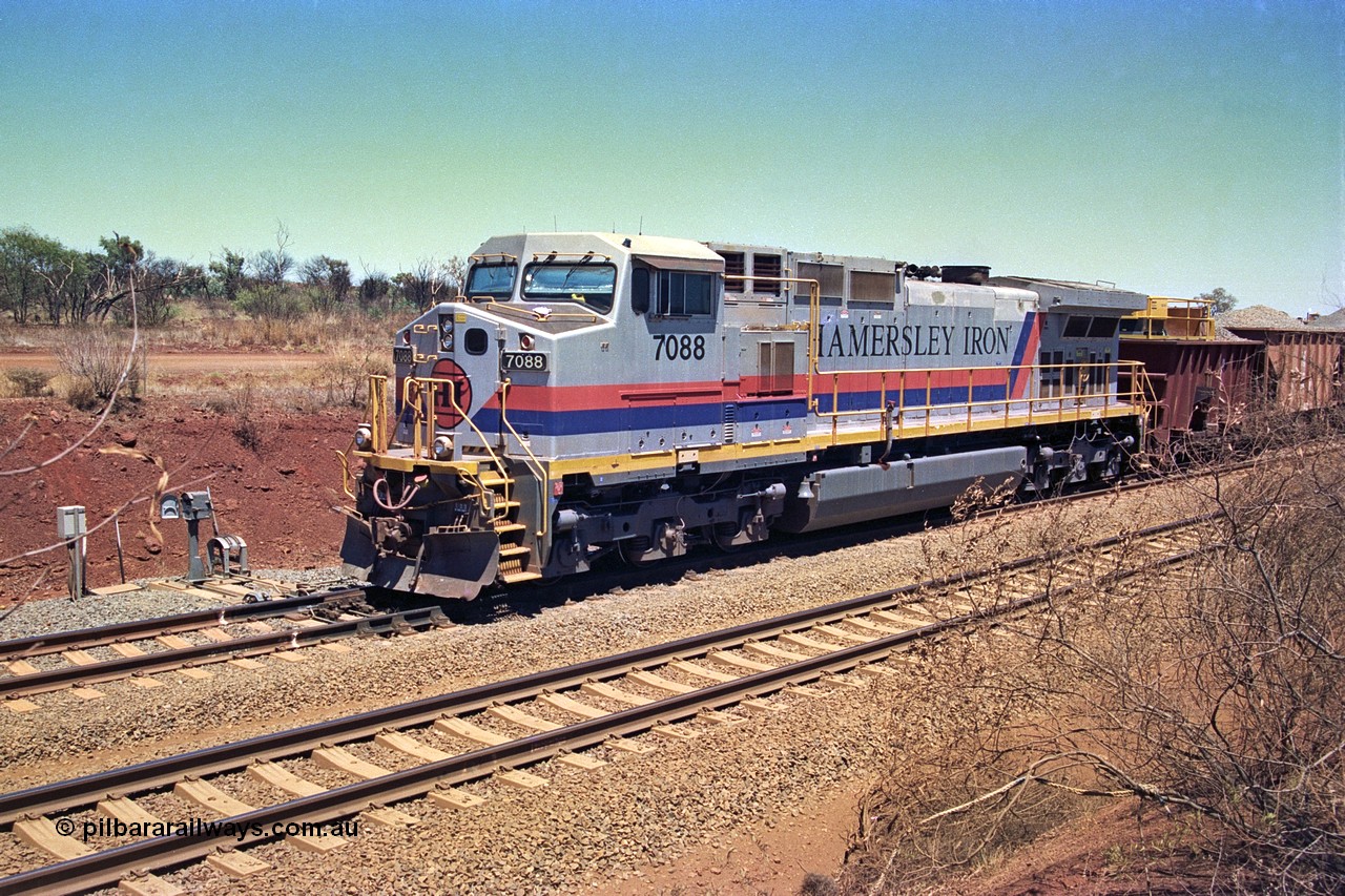 252-04
Cockatoo Siding 273 km on the Hamersley Iron line to Yandi, General Electric built 9-44CW unit 7088 with serial number 47767 from the original 1994 build idles away on the eastern end of the ballast train as it is loaded and slowly progresses into the back track siding Ballast plough BP 02 is behind the locomotive. Location is roughly [url=https://goo.gl/maps/bCvLZxMc1z57F8ym9]here[/url]. 24th November 2001.
Keywords: 7088;GE;Dash-9-44CW;47767;