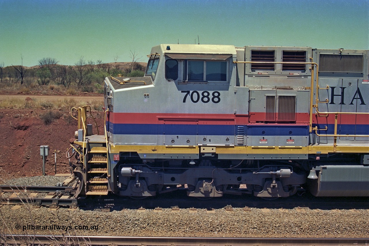 252-07
Cockatoo Siding 273 km on the Hamersley Iron line to Yandi, General Electric built 9-44CW unit 7088 with serial number 47767 from the original 1994 build idles away on the eastern end of the ballast train. Cab side view. Location is roughly [url=https://goo.gl/maps/bCvLZxMc1z57F8ym9]here[/url]. 24th November 2001.
Keywords: 7088;GE;Dash-9-44CW;47767;