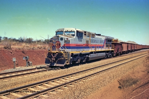 252-05
Cockatoo Siding 273 km on the Hamersley Iron line to Yandi, General Electric built 9-44CW unit 7088 with serial number 47767 from the original 1994 build idles away on the eastern end of the ballast train as it is loaded and slowly progresses into the back track siding Ballast plough BP 02 is behind the locomotive. Location is roughly [url=https://goo.gl/maps/bCvLZxMc1z57F8ym9]here[/url]. 24th November 2001.
Keywords: 7088;GE;Dash-9-44CW;47767;