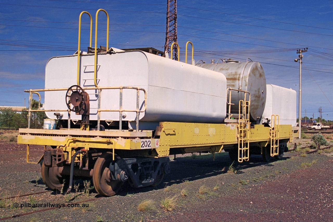 253-36
Nelson Point hard stand area, riveted flat waggon 202 with three water tanks fitted, view of handbrake end, originally part of the 'camp train', modified by Mt Newman Mining railway workshops.
Keywords: BHP-flat-waggon;
