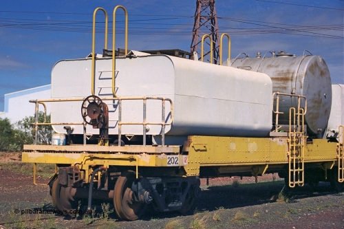 253-37
Nelson Point hard stand area, riveted flat waggon 202 with three water tanks fitted, view of handbrake end, originally part of the 'camp train', modified by Mt Newman Mining railway workshops.
Keywords: BHP-flat-waggon;