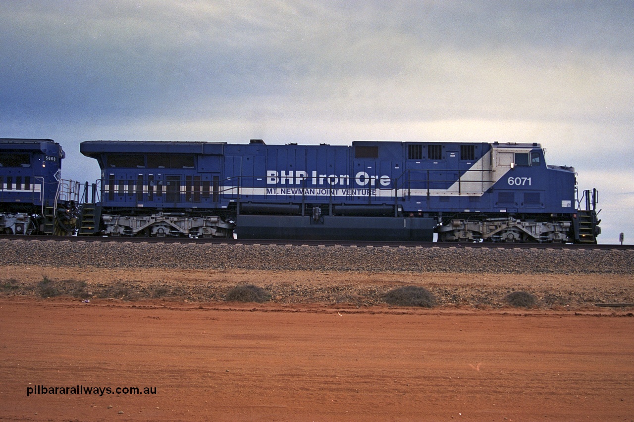 254-19
Bing Siding, an empty train awaits departure time behind 6071 an General Electric built AC6000 model with serial number 51063. The locomotive has not yet been named. Side view. September 2001.
Keywords: 6071;GE;AC6000;51063;