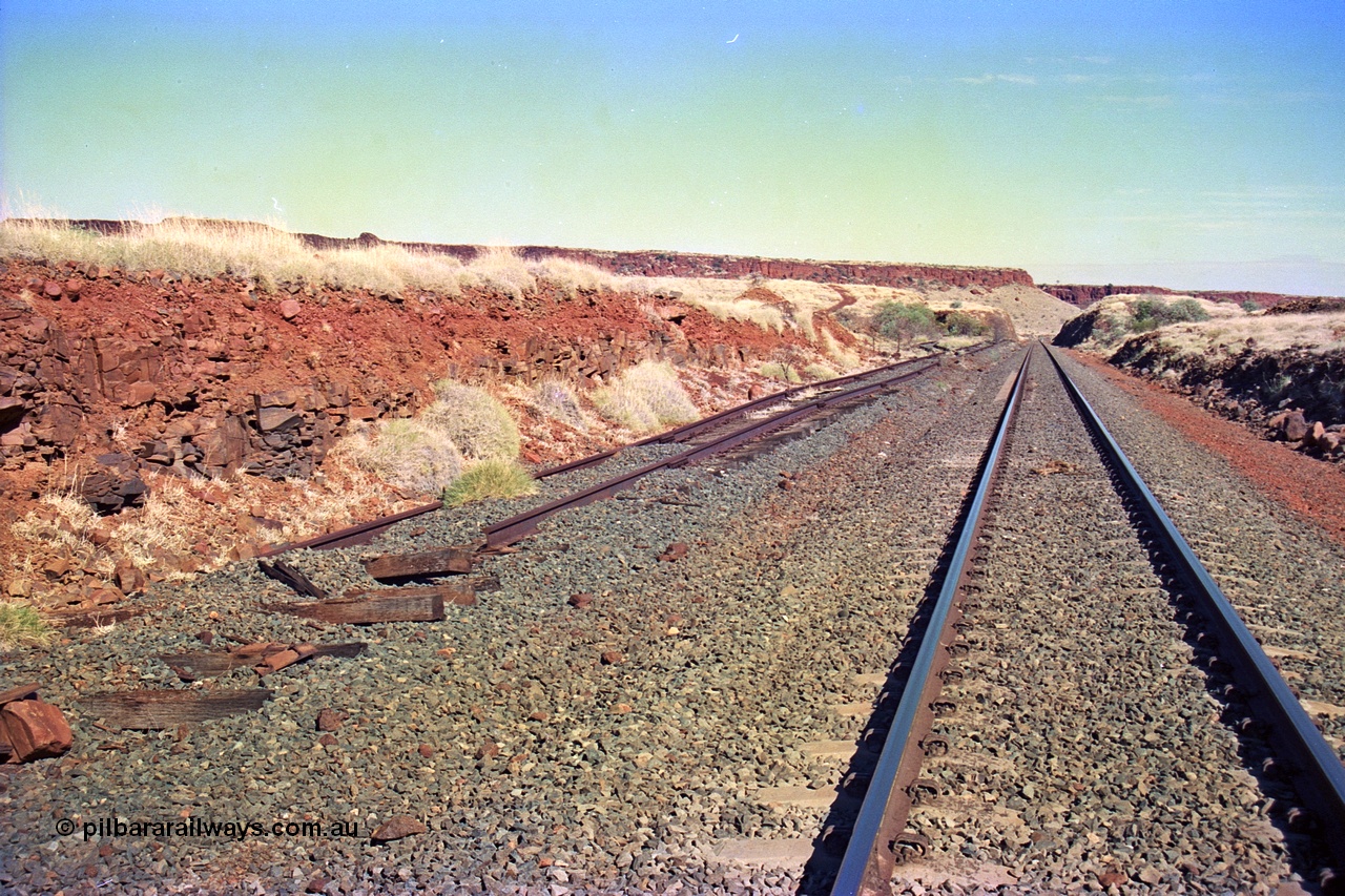 255-11
At the 162.2 km looking south are the remains of the second Robe River loadout facility which was installed in 1975 to mine the Mesa 2402E mining area, the line was a four kilometre U shaped spur. Geodata [url=https://goo.gl/maps/DATgFuHfuayyAp8y9]location here[/url]. May 2002.

