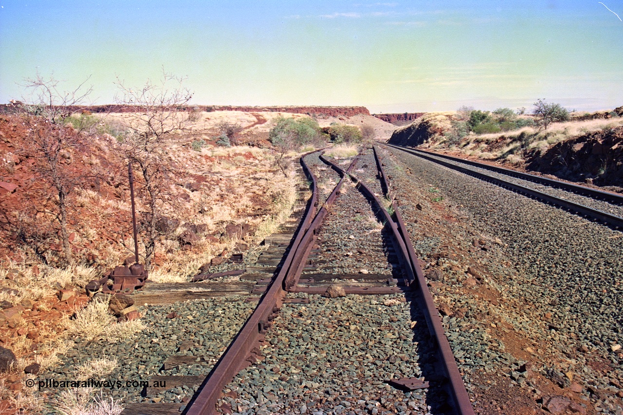 255-12
At the 162.2 km looking south are the remains of the second Robe River loadout facility which was installed in 1975 to mine the Mesa 2402E mining area, the line was a four kilometre U shaped spur. Geodata [url=https://goo.gl/maps/DATgFuHfuayyAp8y9]location here[/url]. May 2002.
