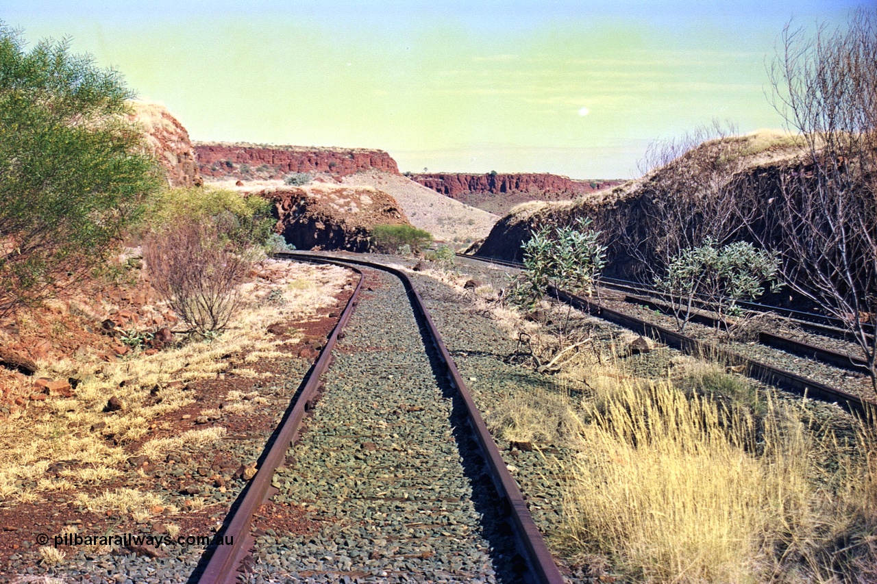 255-13
At the 162.2 km looking south are the remains of the second Robe River loadout facility which was installed in 1975 to mine the Mesa 2402E mining area, the line was a four kilometre U shaped spur. The Deepdale line is on the right. Geodata [url=https://goo.gl/maps/DATgFuHfuayyAp8y9]location here[/url]. May 2002.
