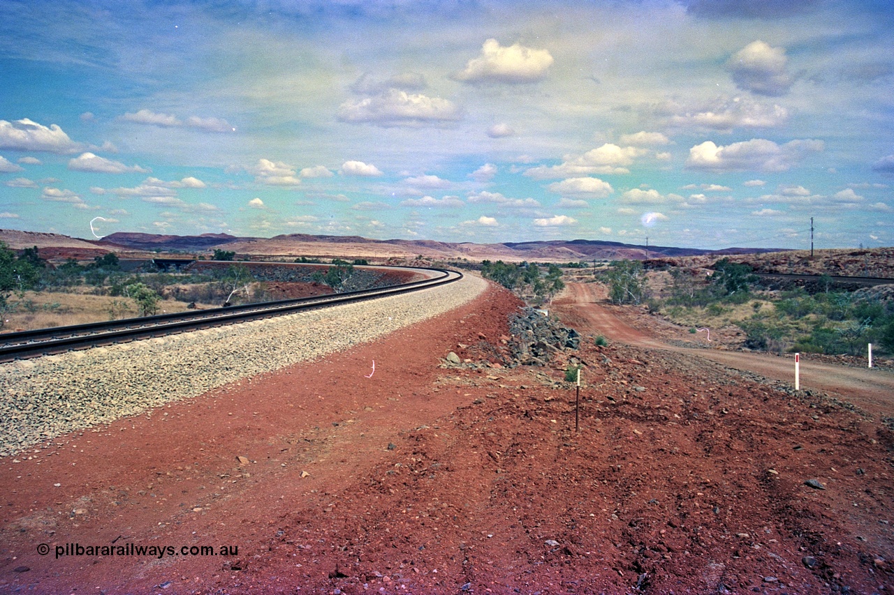 255-24
Western Creek, looking south alongside the Robe River interconnecting line with the Western Creek bridge, on the right is the Hamersley Iron Dampier to Tom Price line. Geodata [url=https://goo.gl/maps/XKJRKgjAEhKLAzgu5]location here[/url]. May 2002.
