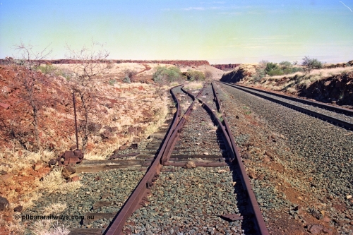 255-12
At the 162.2 km looking south are the remains of the second Robe River loadout facility which was installed in 1975 to mine the Mesa 2402E mining area, the line was a four kilometre U shaped spur. Geodata [url=https://goo.gl/maps/DATgFuHfuayyAp8y9]location here[/url]. May 2002.

