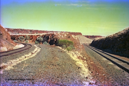 255-14
At the 162.2 km looking south are the remains of the second Robe River loadout facility which was installed in 1975 to mine the Mesa 2402E mining area, the line was a four kilometre U shaped spur curving away to the left while the Deepdale line is on the right. Geodata [url=https://goo.gl/maps/DATgFuHfuayyAp8y9]location here[/url]. May 2002.
