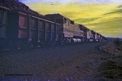 256-36
At the 89.6 km grade crossing the loaded train behind the quad CM40-8M working of 9414, 9420, 9410 and 9425 rolls across the crossing and heads down the 1.26 percent grade. 9425 was built by AE Goodwin NSW as an ALCo C636 in April 1970 with serial G-6041-4 for Mount Newman Mining with road number 5468. It was sold to Robe in August 1982 and repainted and renumbered to 9425. 9425 was rebuilt by Goninan WA in August 1989 to become an CM40-8M model with serial 6266-8 / 89-85. May 2002.
Keywords: 9425;Goninan;GE;CM40-8M;6266-8/89-85;rebuild;AE-Goodwin;ALCo;M636;G-6041-4;