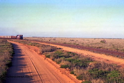257-23
Goldsworthy Junction, an empty train runs between the junction and the Broome Rd crossing behind the standard single locomotive 5646 'White Springs', a Goninan 1992 built GE CM40-8 model with serial number 5244-11 / 92-135. Late 2001.
Keywords: 5646;Goninan;GE;CM40-8;8244-11/92-135;