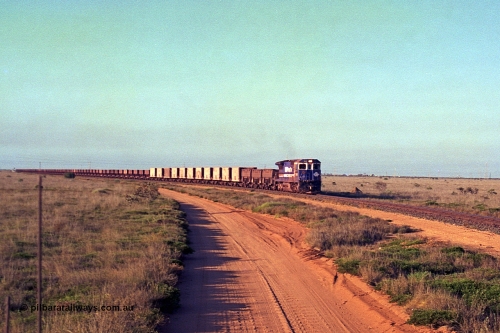 257-24
Goldsworthy Junction, an empty train runs between the junction and the Broome Rd crossing behind the standard single locomotive 5646 'White Springs', a Goninan 1992 built GE CM40-8 model with serial number 5244-11 / 92-135. Late 2001.
Keywords: 5646;Goninan;GE;CM40-8;8244-11/92-135;