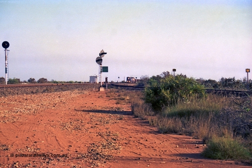 257-28
Goldsworthy Junction looking north as an empty train approaches, the line curving in from the right in the Goldsworthy or Yarrie line. The dual searchlight signal is GJ 9 and is so positioned to allow approaching trains to see the junction signal, like a repeater. Late 2001.
