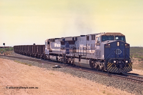 267-06
Goldsworthy Junction, BHP's 1230 empty departure behind General Electric AC6000 unit 6076 'Mt Goldsworthy' serial number 51068 leads CM40-8MEFI 5669 on the point with mid-train units CM40-8M units 5651 and 5645 104 waggons back with 104 waggons trailing. 1247 hrs 12th of April 2002.
Keywords: 6076;GE;AC6000;51068;