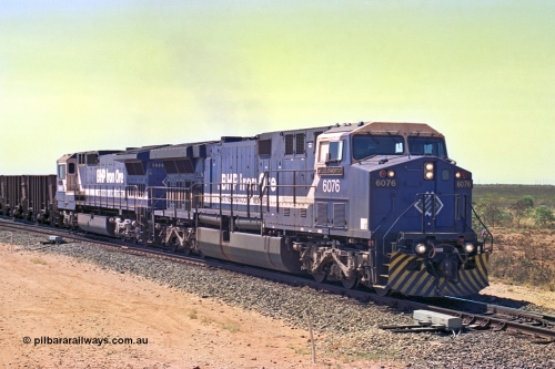 267-07
Goldsworthy Junction, BHP's 1230 empty departure behind General Electric AC6000 unit 6076 'Mt Goldsworthy' serial number 51068 leads CM40-8MEFI 5669 on the point with mid-train units CM40-8M units 5651 and 5645 104 waggons back with 104 waggons trailing. 1247 hrs 12th of April 2002.
Keywords: 6076;GE;AC6000;51068;