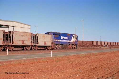 275-04
Boodarie, BHP Iron Ore's CM40-8 locomotive 5646 'White Springs' arrives along the mainline as it is bound for the unloading hopper at Finucane Island as it passes rebuilt CM40-8M unit 5645 in the prep bay. The fuel tank and bogies shows that 5646 was a new build, serial number 8244-11 / 92-135 and built by Goninan in November 1992, the same build date as 5645. The waggons behind 5646 are former Phelp Dodge hoppers built by Gunderson in the USA and purchased by BHP in 1992. August 10, 2003.
Keywords: 5646;Goninan;GE;CM40-8;8244-11/92-135;