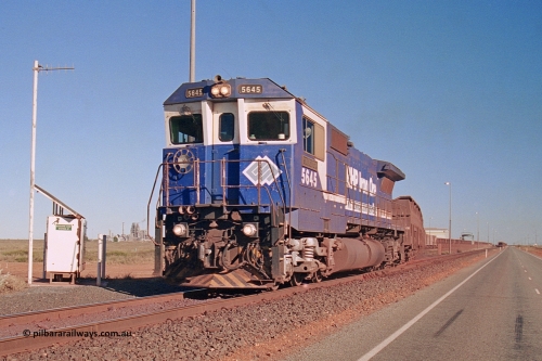 275-13
Boodarie, BHP Iron Ore's 5645 'Sherlock' an Goninan CM40-8M Alco to GE rebuild, departs the service road on its way to Yarrie with an empty, on the left is the Boodarie East interlocking cabinet and the HBI plant is visible. This scene has changed immensely since this image was taken, there is another line located where the bitumen road is, the HBI is gone and the is a turn wye and fuel roads pretty much behind those shrubs. August 10, 2003.
Keywords: 5645;Goninan;GE;CM40-8M;8281-11/92-134;rebuild;AE-Goodwin;ALCo;M636C;5475;G6047-7;