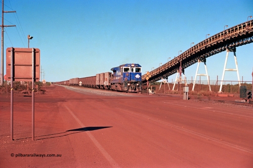 275-17
Finucane Island, BHP Iron Ore's CM40-8 locomotive 5646 'White Springs' arrives at the island across the -0.8 km grade crossing and the No. 6 switch where the balloon loops rejoins the mainline. The elevated conveyor is for the HBI plant. August 10, 2003.
Keywords: 5646;Goninan;GE;CM40-8;8244-11/92-135;