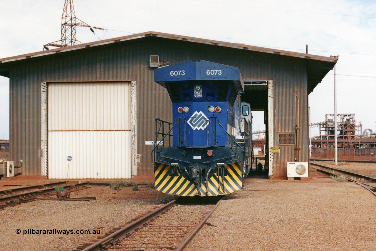 283-03
Nelson Point, BHP wheel lathe sees BHP's big GE AC6000 unit 6073 'Fortescue' serial number 51065 on shed having wheel attention to the leading bogie. May 2002.
Keywords: 6073;GE;AC6000;51065;