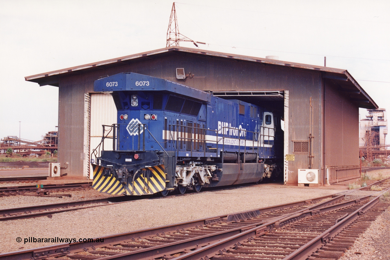 283-04
Nelson Point, BHP wheel lathe sees BHP's big GE AC6000 unit 6073 'Fortescue' serial number 51065 on shed having wheel attention to the leading bogie. May 2002.
Keywords: 6073;GE;AC6000;51065;