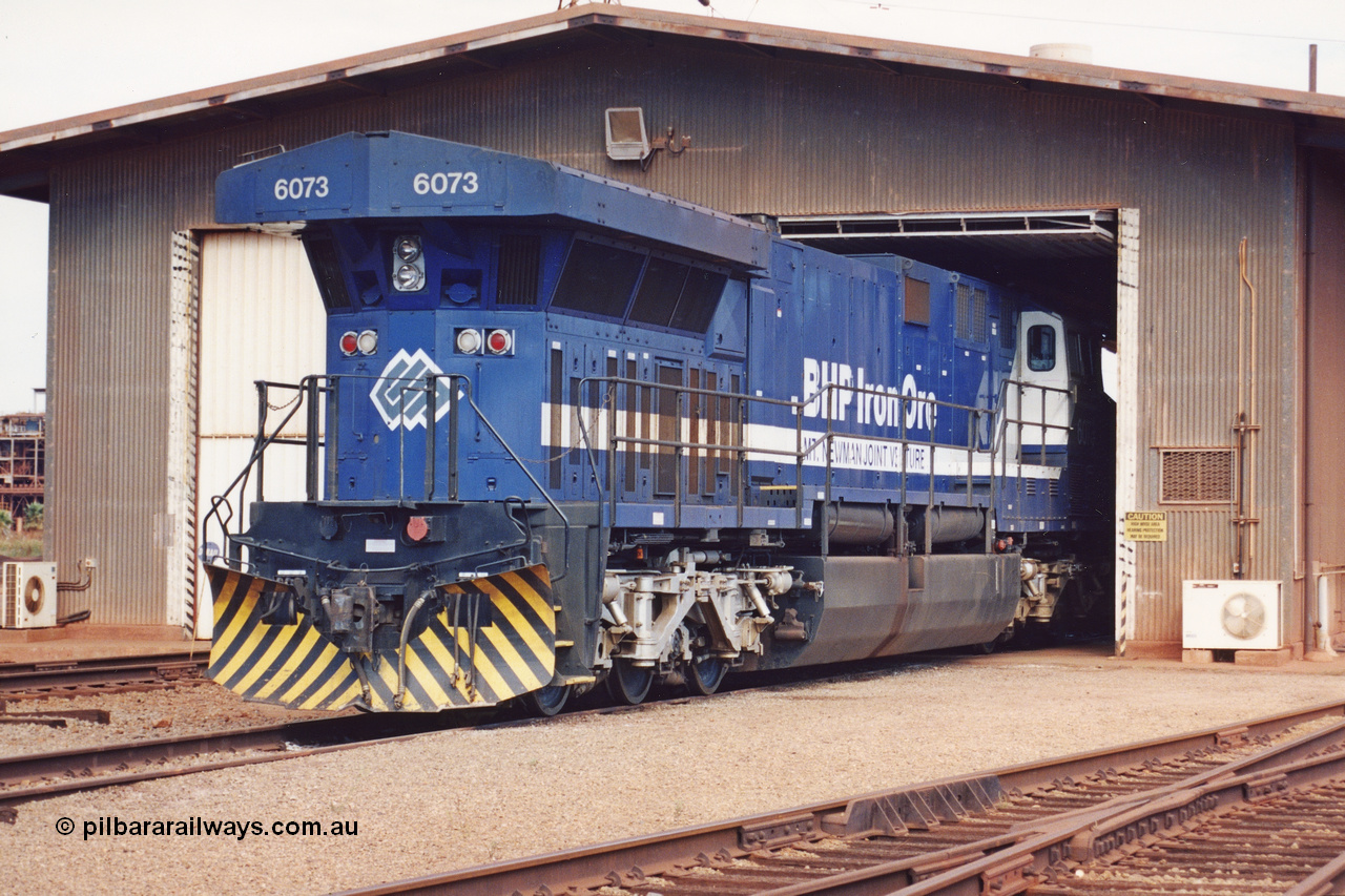 283-05
Nelson Point, BHP wheel lathe sees BHP's big GE AC6000 unit 6073 'Fortescue' serial number 51065 on shed having wheel attention to the leading bogie. May 2002.
Keywords: 6073;GE;AC6000;51065;
