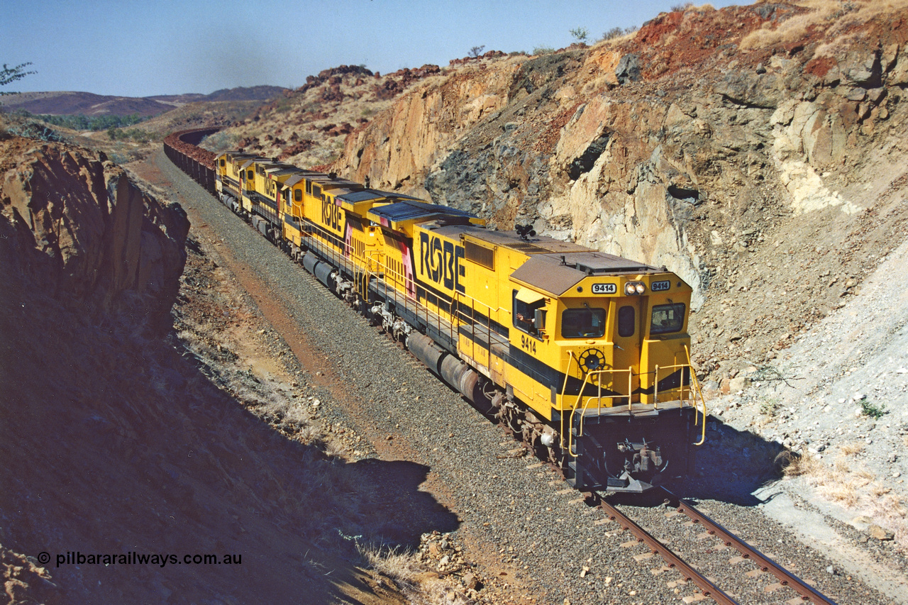 283-33
Near Woodbrook as quad Robe River CM40-8M units 9414, 9420, 9410 and 9525 work a loaded 202 waggons bound for Cape Lambert as they power through the cutting up a short grade at the 37.5 km pipe bridge. 9414 with serial number 8206-11 / 91-124 was rebuilt by Goninan in 1991 from AE Goodwin built M636 ALCo model with original serial number G-6060-5 from 1971. 22nd of May 2002.
Keywords: 9414;Goninan;GE;CM40-8M;8206-11/91-124;rebuild;AE-Goodwin;ALCo;M636;G6060-5;