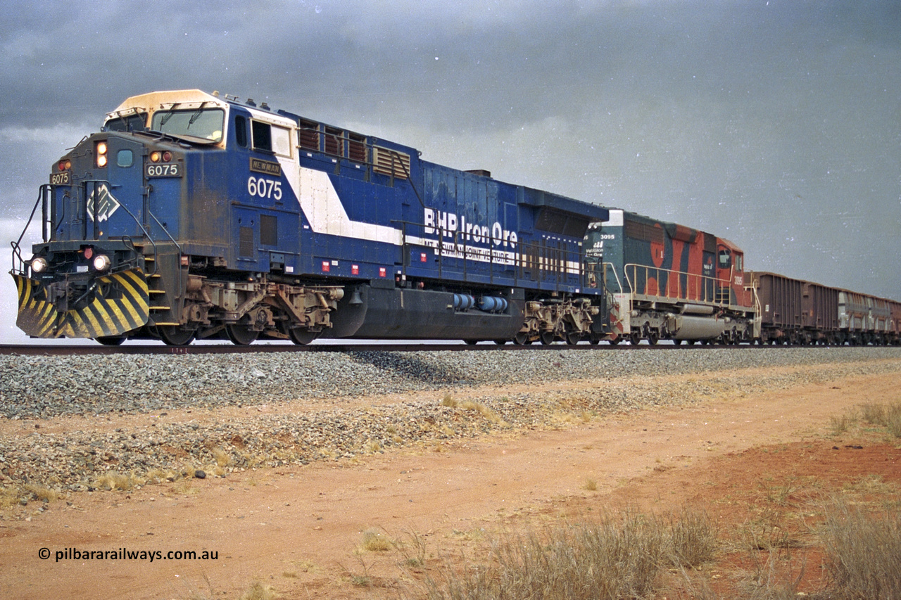 284-34
Bing Siding, 18 km south of Nelson Point and BHP's GE built AC6000 unit 6075 'Newman', serial number 51097, holds the mainline with a loaded train and EMD SD40R unit 3095 as second unit. Late 2004.
Keywords: 6075;GE;AC6000;51067;