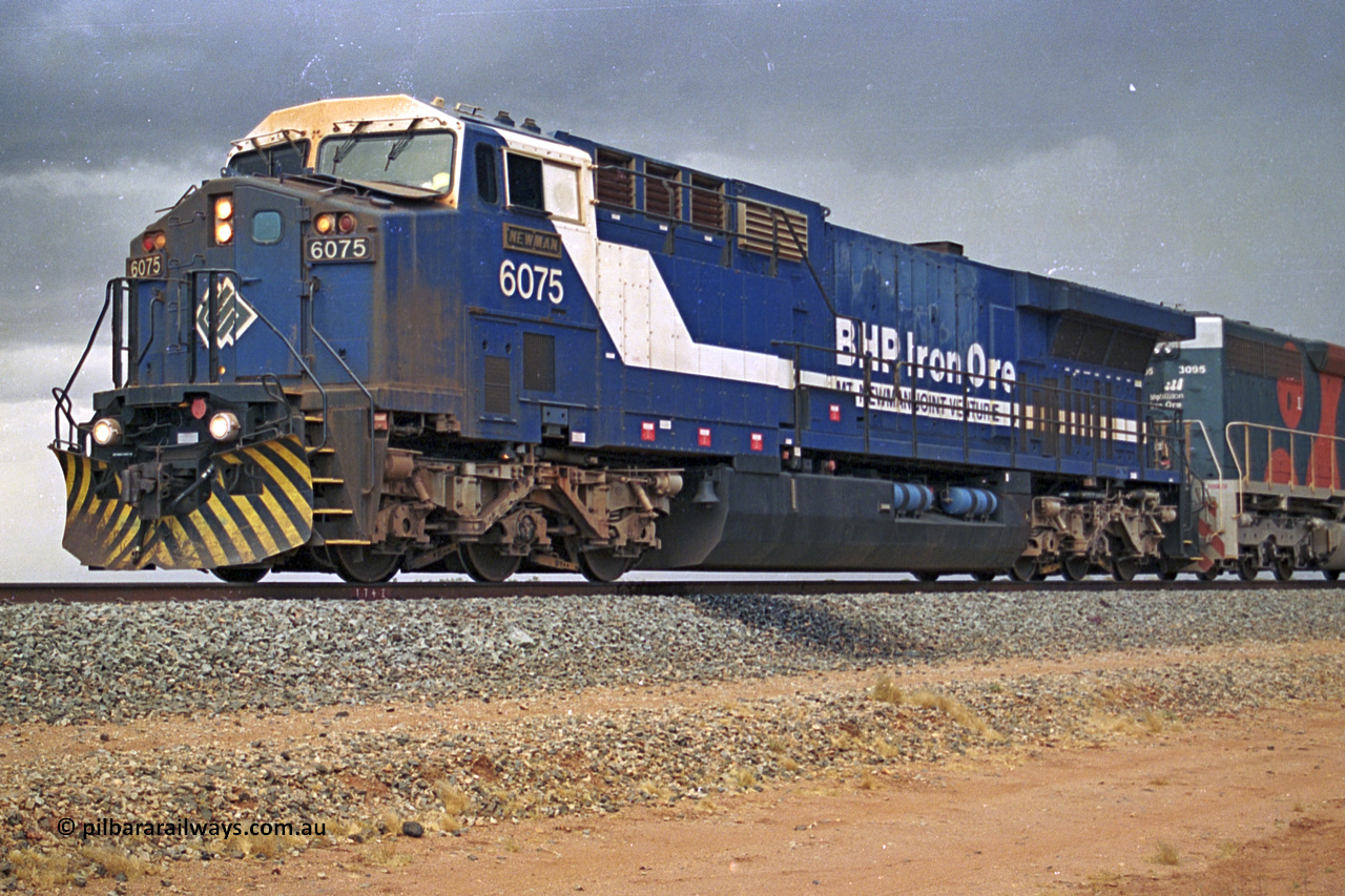 284-35
Bing Siding, 18 km south of Nelson Point and BHP's GE built AC6000 unit 6075 'Newman', serial number 51097, holds the mainline with a loaded train and EMD SD40R unit 3095 as second unit. Late 2004.
Keywords: 6075;GE;AC6000;51067;