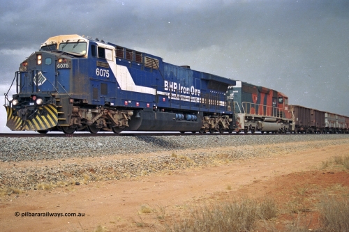 284-34
Bing Siding, 18 km south of Nelson Point and BHP's GE built AC6000 unit 6075 'Newman', serial number 51097, holds the mainline with a loaded train and EMD SD40R unit 3095 as second unit. Late 2004.
Keywords: 6075;GE;AC6000;51067;