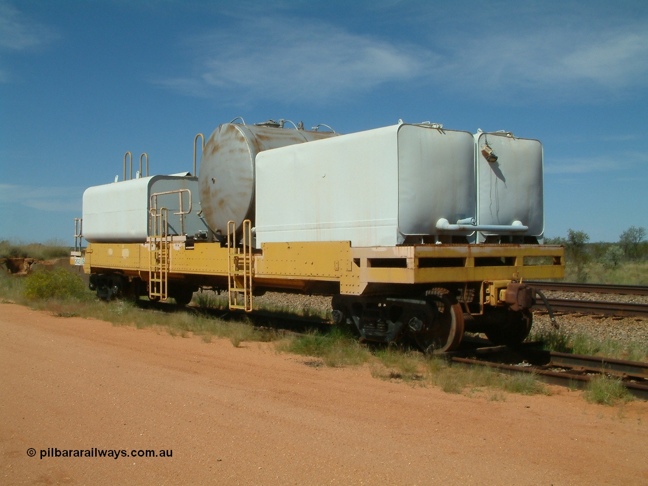 040419 102228
Abydos back track, riveted flat waggon 202 with three water tanks fitted, 3/4 view from non-handbrake end, shows access ladder profiles, originally part of the 'camp train', modified by Mt Newman Mining railway workshops.
Keywords: BHP-flat-waggon;