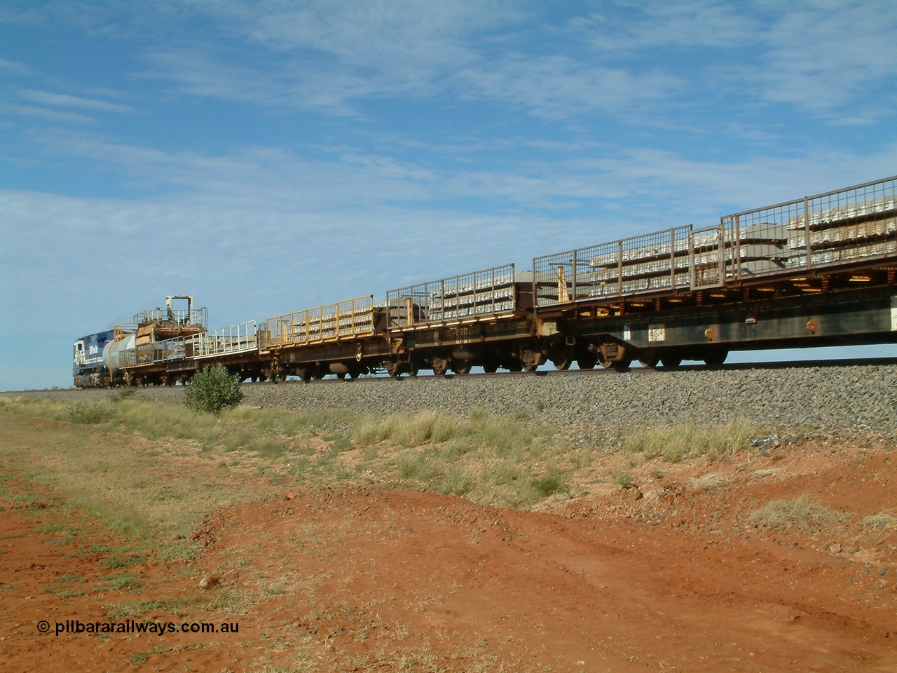 040502 085554
Mooka Siding, trailing view of the 'Pony' heading south, 50 ton waggon 6701, one of three 'special' waggons converted from Magor USA built ore waggons, loaded with concrete sleepers is in the middle with former Goldsworthy flat waggon 8704 closet to camera. 
Keywords: Magor-USA;BHP-pony-waggon;