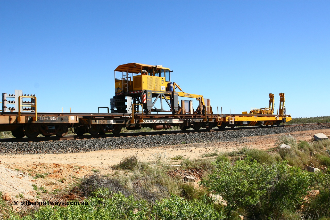 080621 2721
Tabba South, rail recovery and transport train flat waggon #1, rear lead off waggon 6203, built by Comeng WA in January 1977. The straddle crane is a newish unit built by Vaia Car model no. TCR-V and the four wheels are chain driven, replacing the original Gemco hydraulic unit.
Keywords: Comeng-WA;BHP-rail-train;