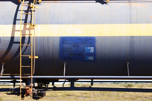 0012 Comeng NSW 050704 3972
Bing Siding, empty 116 kL Comeng NSW built tank waggon 0012 from 1972, one of three such tank waggons, view of data placard, ladder and valving, on the rear of a loaded ore train.
Keywords: Comeng-NSW;BHP-tank-waggon;