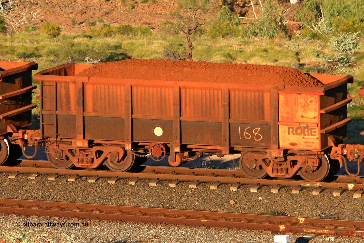 0168 110602 1621
Robe River ore waggon 168, built by Nippon Sharyo Nihon, rotary coupler end handbrake side loaded view at the 71 km, Western Creek on the Deepdale line. June 2, 2011.
Keywords: 168;Nippon-Sharyo-Nihon;Robe-ore-waggon;