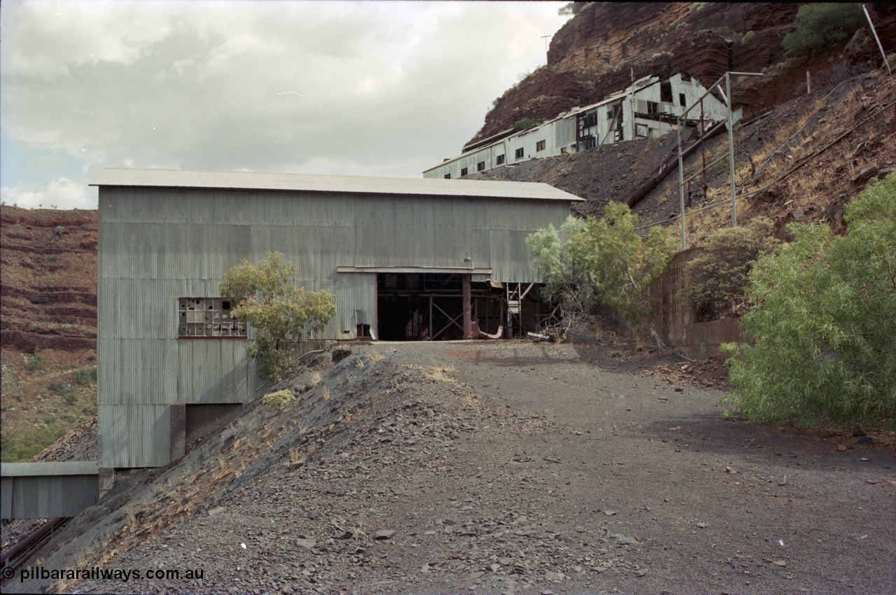 194-01
Wittenoom Gorge, Colonial Mine, asbestos mining remains, view of building that houses the crusher, slide chute for conveying ore from the waggons from the upper level is visible, along with upper level buildings for the miners and railway.
