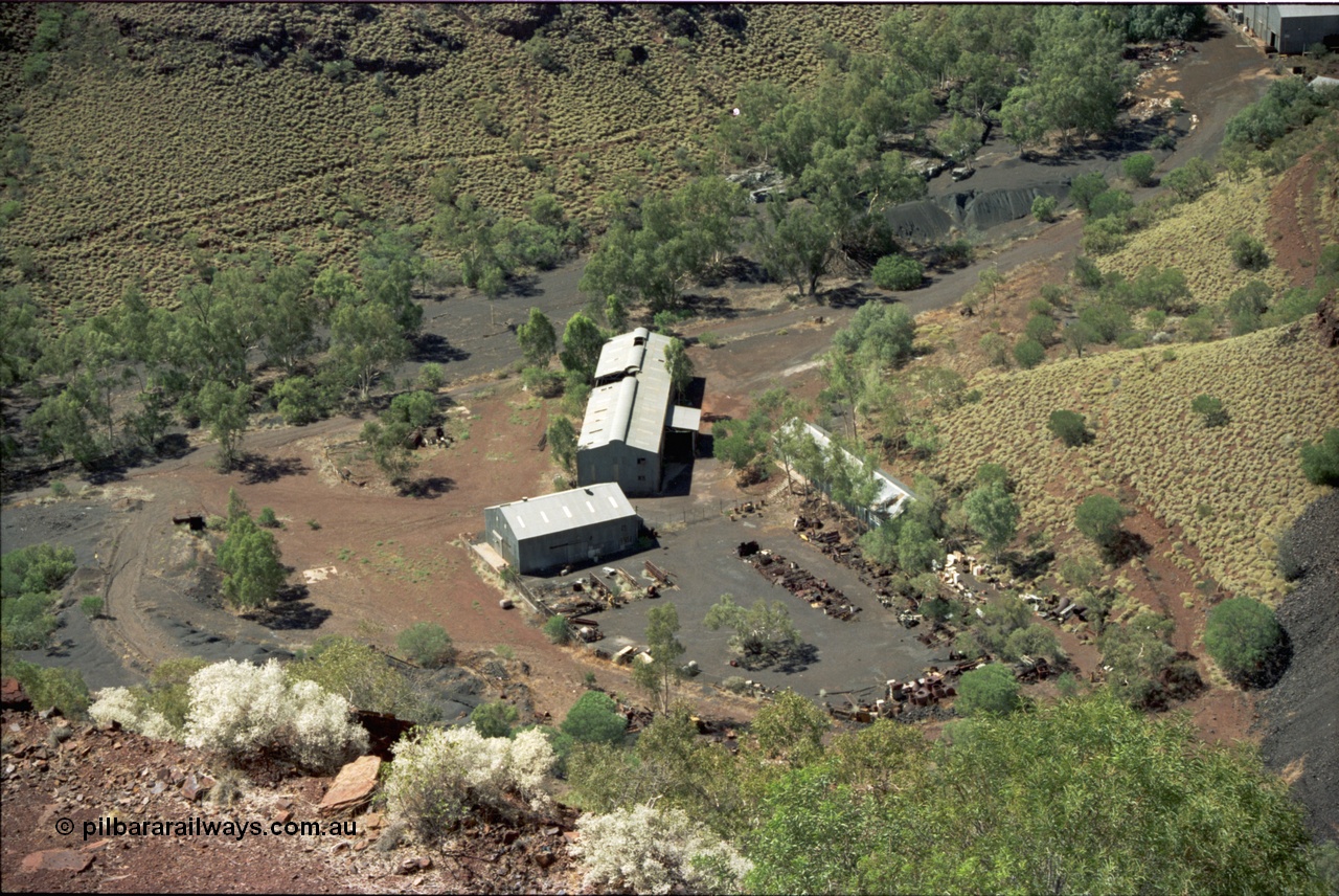 195-17
Wittenoom Gorge, Australian Blue Asbestos or ABA Colonial Mill view of stores or warehouse building and fenced yard and the maintenance workshop shed.
