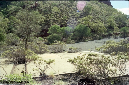 196-29
Wittenoom Gorge, Gorge Mine area, asbestos mining remains, view of demolished building with railway tracks and pit in concrete floor, locomotive workshops.
