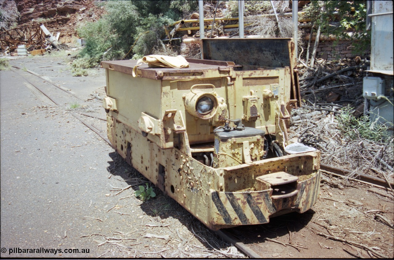 197-27
Wittenoom, Colonial Mine, battery module No.1, shows a slotted drop type hinge arrangement, headlight, English Electric hauler with Dick Kerr DB1 control stand, drivers position and coupling pocket, demolished underground offices and lamp room in the background
Keywords: Dick-Kerr;DB1;English-Electric;
