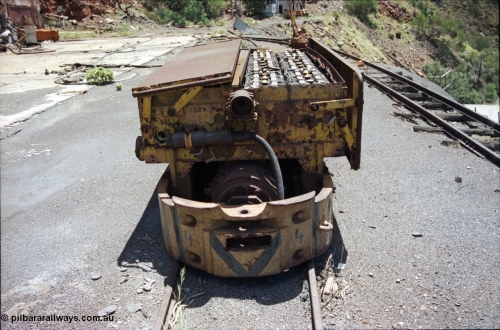 197-14
Wittenoom, Colonial Mine, asbestos mining remains, Mancha battery locomotive #4 looking north west, demolished workshops and office on the left, mine adit doors visible, compressor building in the distance.
Keywords: Mancha;