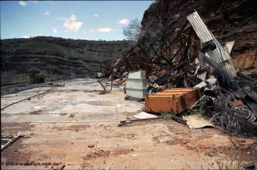 197-20
Wittenoom, Colonial Mine, asbestos mining remains, view of the demolished underground shift offices, upturned battery module, charging transformer, Mancha #4 battery locomotive on the right.
