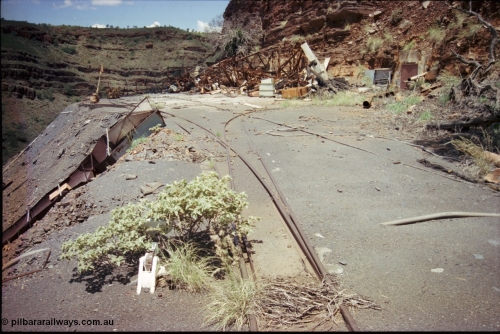 197-22
Wittenoom, Colonial Mine, asbestos mining remains, view of the points leading to the mine adit on the right, and past the discharge slide chute on the left. The loop road is visible in the distance, with the demolished underground offices and lamp room pushed up against the gorge wall. Mancha #4 in the distance.
