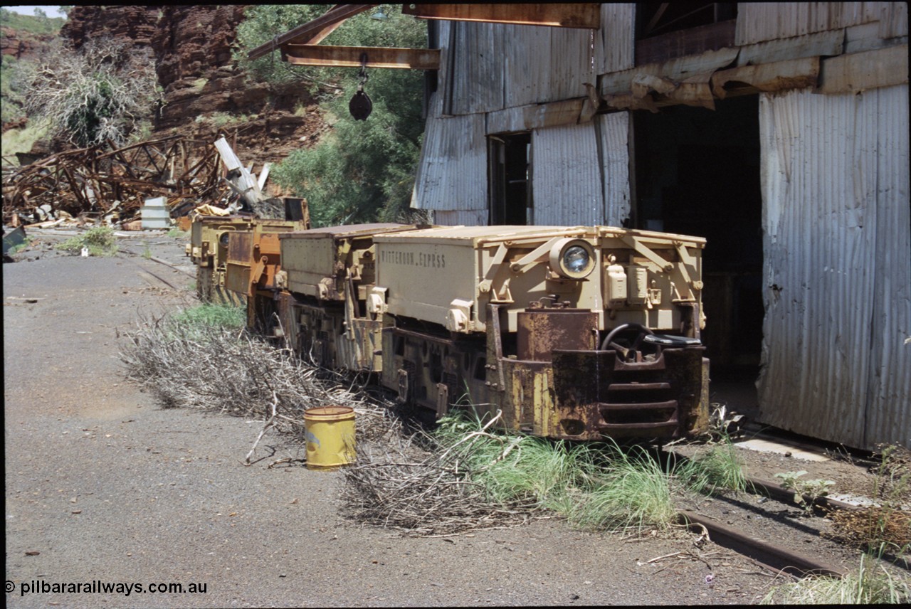 198-07
Wittenoom, Colonial Mine, asbestos mining remains, line up of two Mancha locomotives and the Gemco, then an English Electric. In the background is the demolished locomotive changing and maintenance shed. The building on the right is the compressor and water treatment plant sheds, the lead unit has Wittenoom Exprss stencilled on the battery box, this unit now resides at the Pilbara Railways Historical Society near the 7 Mile complex in Dampier.
Keywords: Mancha;English-Electric;Gemco;