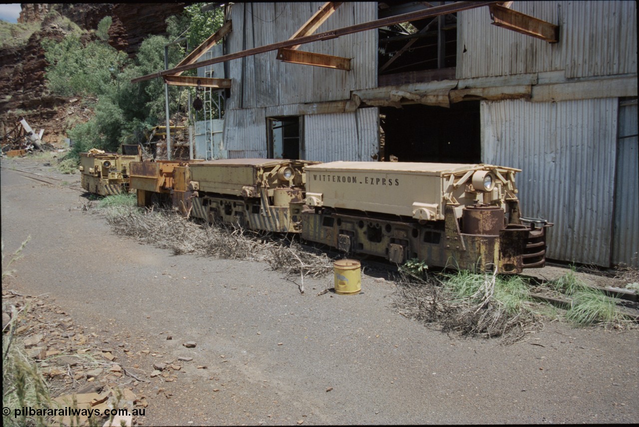 198-08
Wittenoom, Colonial Mine, asbestos mining remains, line up of two Mancha locomotives and the Gemco, then an English Electric. In the background is the demolished locomotive changing and maintenance shed. The building on the right is the compressor and water treatment plant sheds, the lead unit has Wittenoom Exprss stencilled on the battery box, this unit now resides at the Pilbara Railways Historical Society 6 Mile Museum located near the Rio Tinto 7 Mile complex at Dampier.
Keywords: Mancha;English-Electric;Gemco;