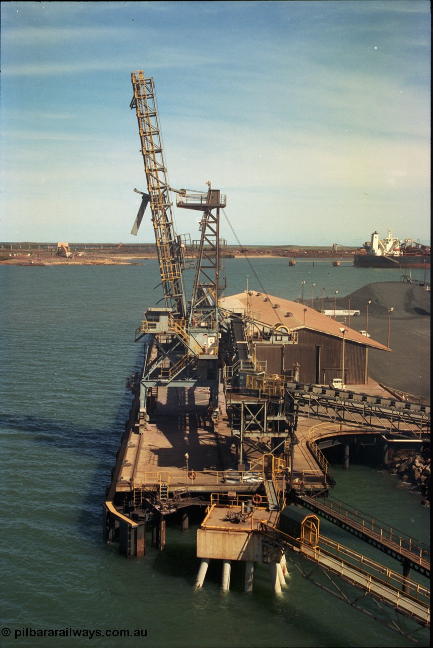 198-21
Port Hedland Port, view of the Cargill Salt berth and loader, or PHPA Berth No. 3, in this 2001 view, manganese is stockpiled on the ground. The BHP Finucane Island berth is visible along with the portal for the under-harbour tunnel and overland conveyor for the HBI plant.

