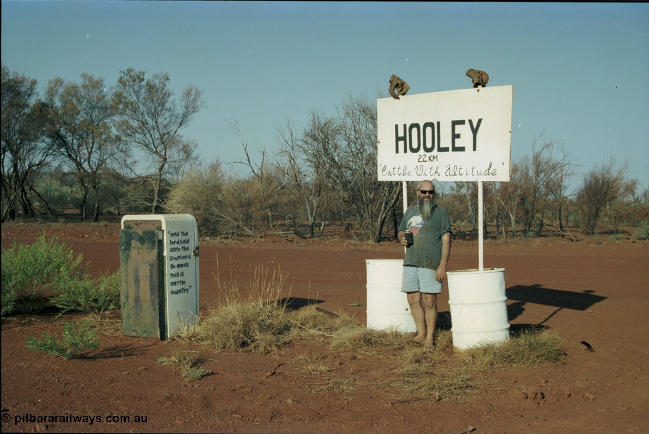 205-03
Hooley Station front gate on Roebourne - Wittenoom Road, Pope Searle celebrating with a cold beverage.
