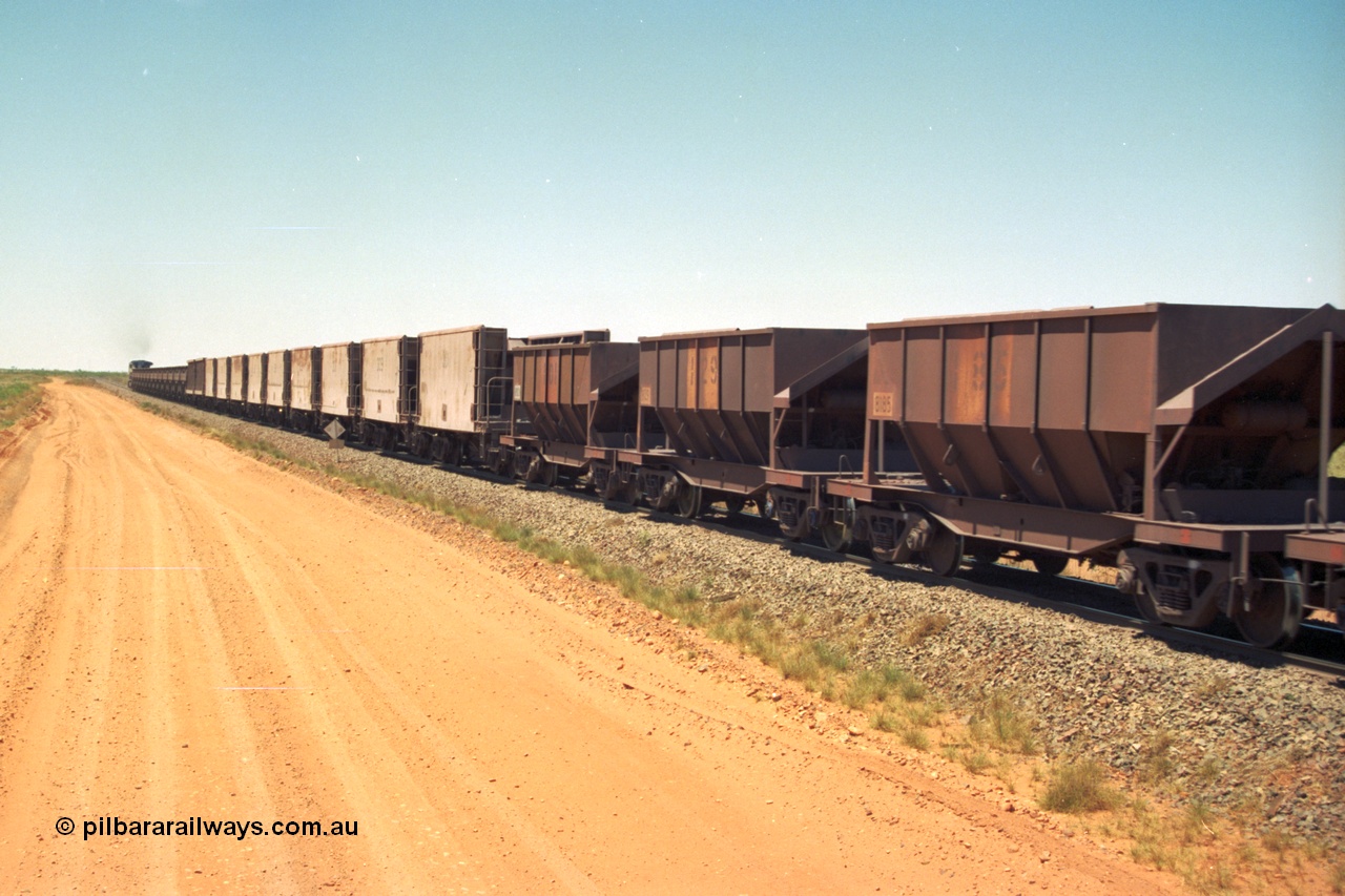 206-33
An empty train on the Yarrie (former Goldsworthy) line with a string of Golynx ore waggons, built by Goninan WA to a Lynx Engineering design, and then the two types of the waggons from the Phelps Dodge Copper Mine, the ribbed units are built by Portec USA and the smooth ones built by Gunderson USA and finally the Tomlinson Steel WA built hopper waggons. All of these are belly dump waggons as opposed to the BHP fleet of rotary dump bodies.
Keywords: 8185;Tomlinson-Steel-WA;BHP-ore-waggon;